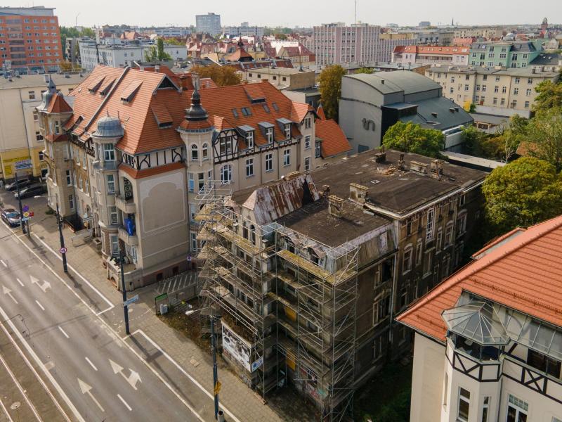 Widok z lotu ptaka na ulicę Roosevelta. W centrum, otoczona rusztowaniem i dwoma innymi budynkami, stoi stara, zaniedbana kamienica, którą miasto oddało do rozbiórki.