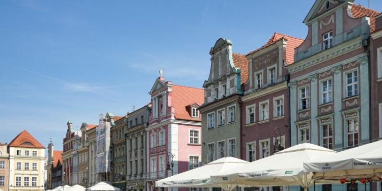 Stary Rynek, kolorowe kamienice, ludzie spędzający czas w kawiarniach i restauracjach
